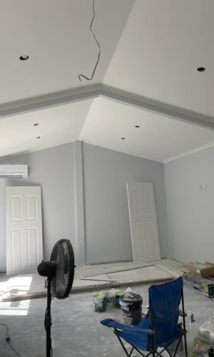 Next Level Painting professional rolling white paint on a living room feature wall in Adelaide