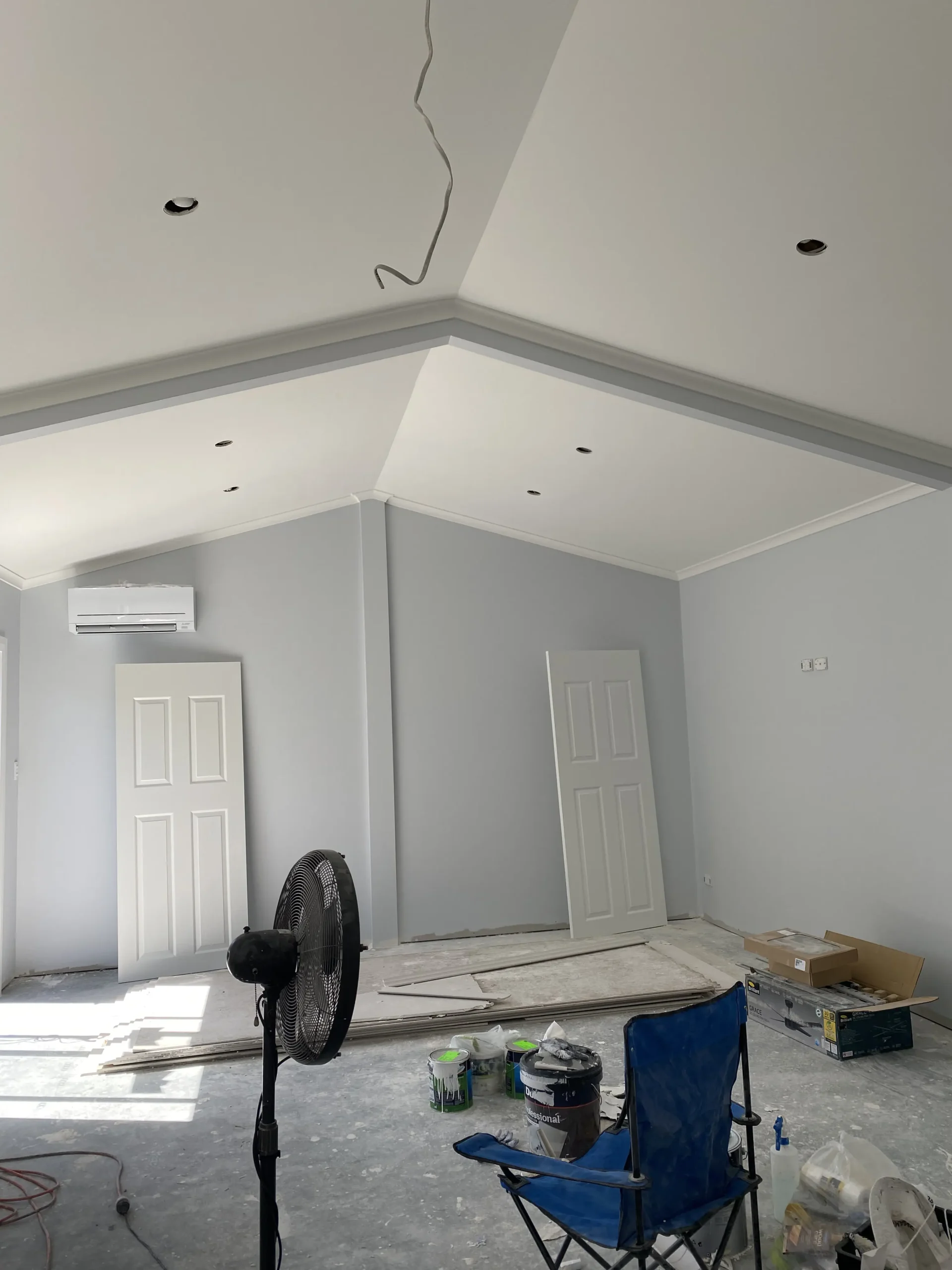 Next Level Painting professional rolling white paint on a living room feature wall in Adelaide