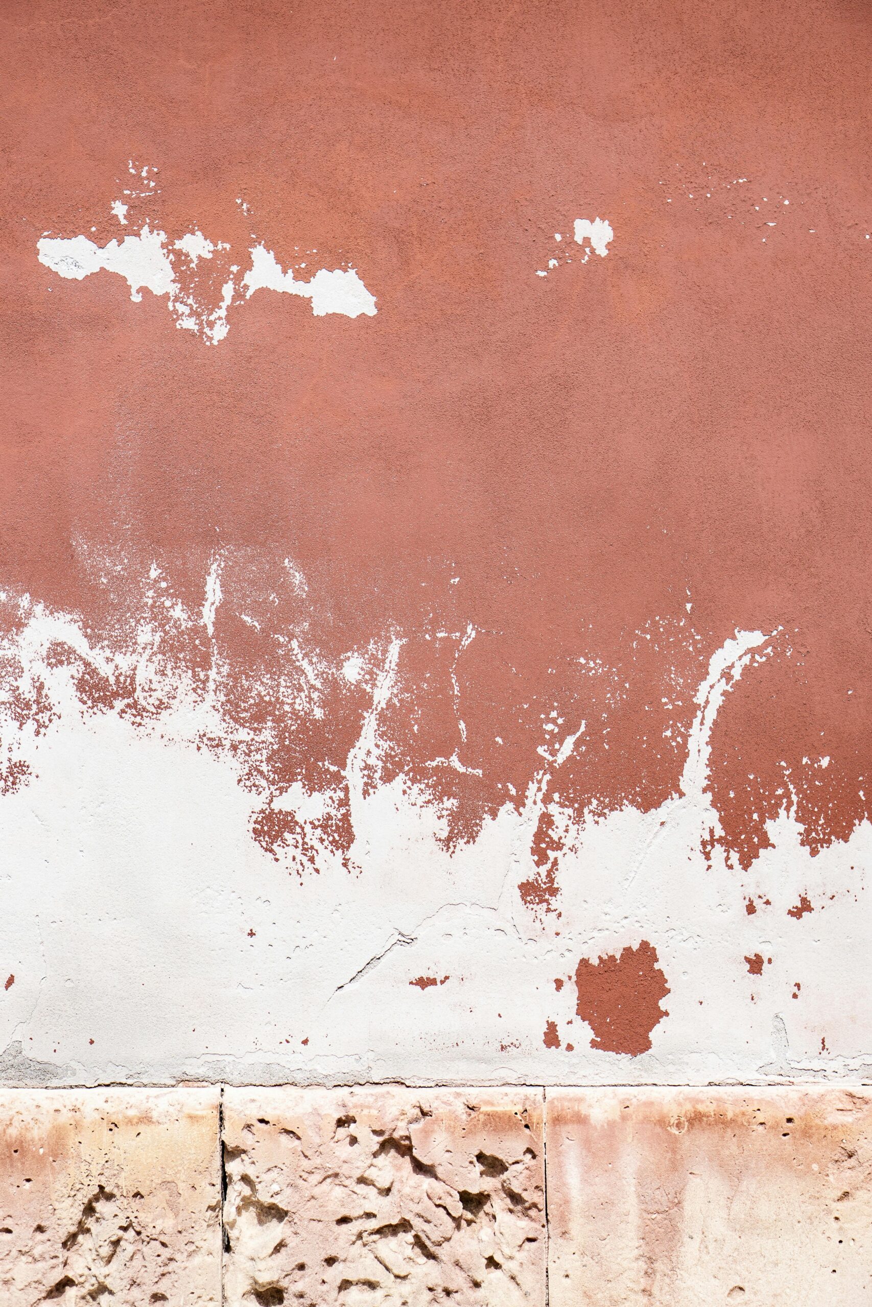 Close-up view of a weathered wall with peeling paint, showcasing a rustic and textured aesthetic.